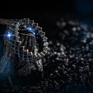 Ring of the jewelry with blue stones on dark background