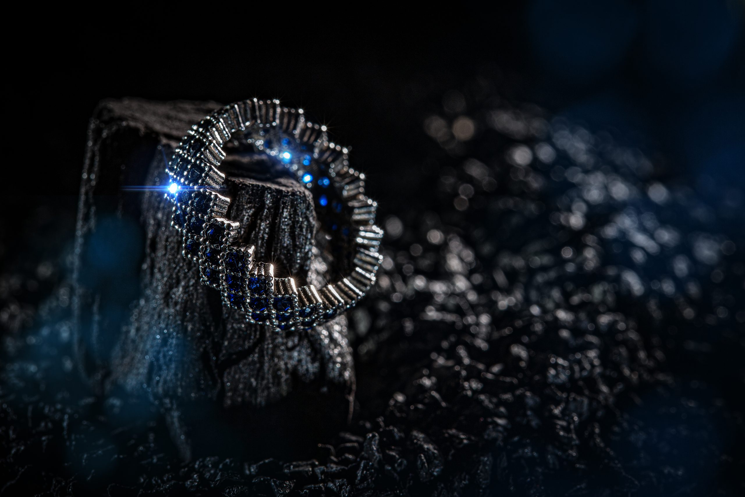 Ring of the jewelry with blue stones on dark background